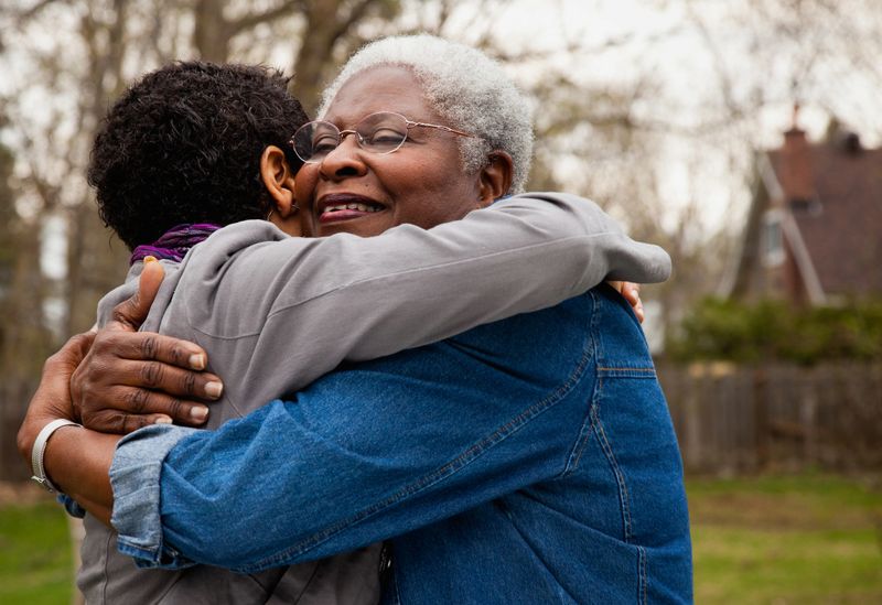 African American senior hugging her daughter