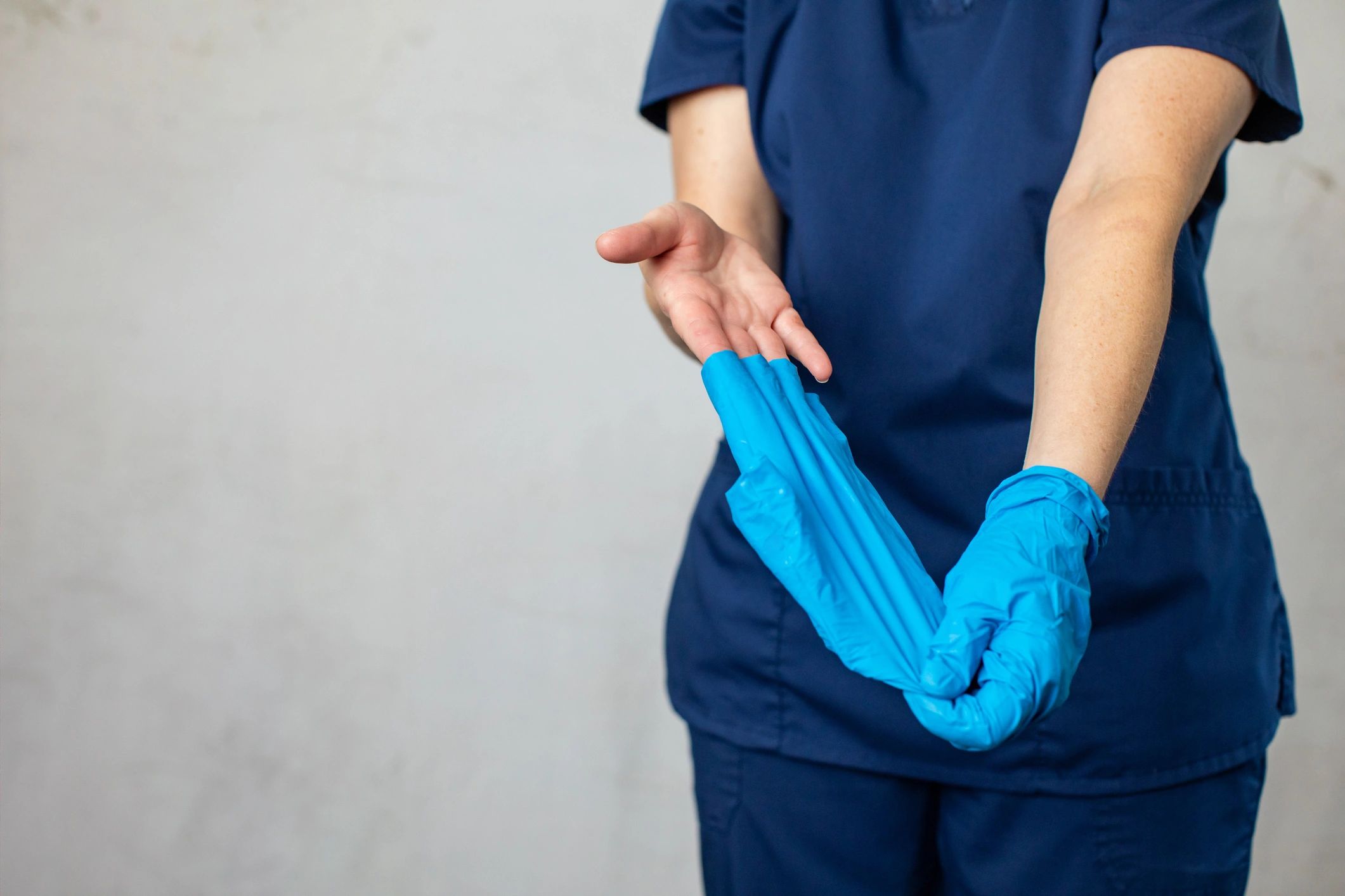 Trabajador poniéndose guantes de nitrilo azules antes de una tarea