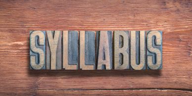 The word 'SYLLABUS' in block letters on wooden background.