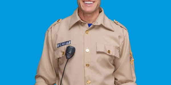 Smiling sheriff in uniform against a blue background.