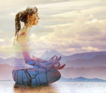 A woman meditating in a serene double exposure with nature and mountains.