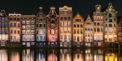 Amsterdam from the canal with buildings lit up at night