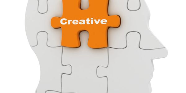 Orange puzzle piece labeled 'Creative' fitting into a white head-shaped puzzle.