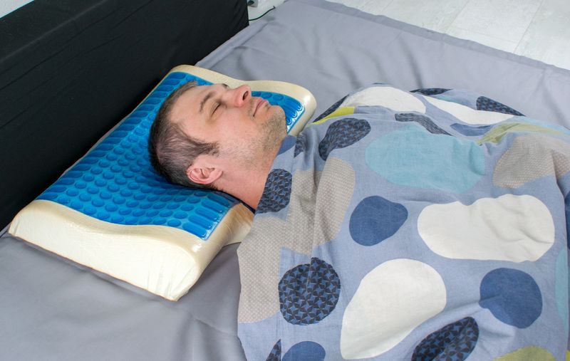 Men lying on bed with orthopedic pillow. Healthy posture concept. Latex pillow with memory foam effect, hydro gel layer. Medical treatment pillow for sleep under the head with a recess under the neck.