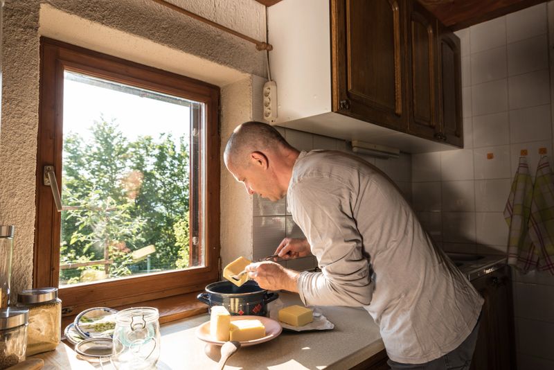 Man in Domestic Kitchen Preparing Butter for Making Ghee