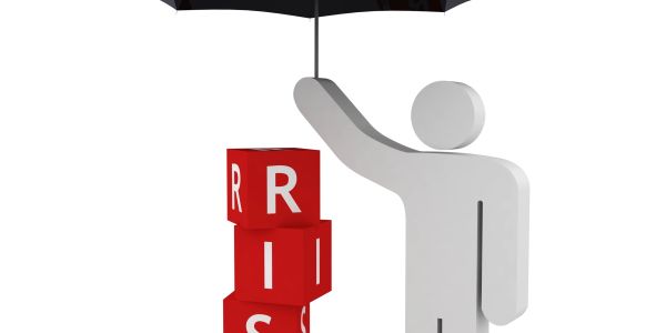 3D figure shielding red blocks spelling 'RISK' with an umbrella.