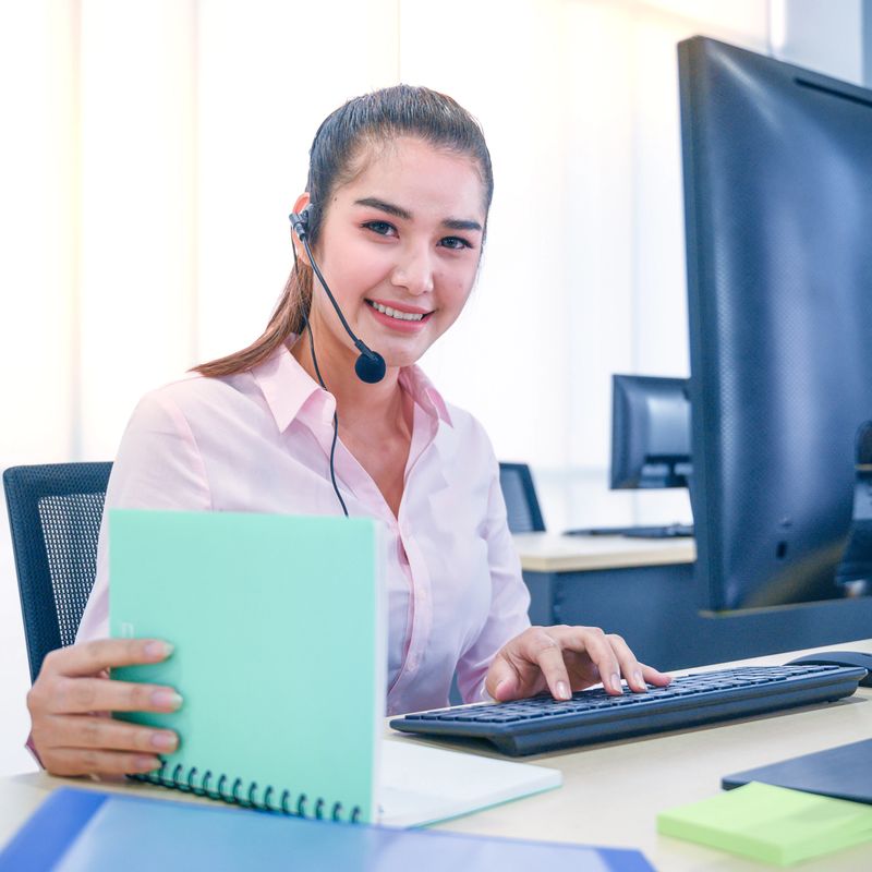 Young customer service women agent with headsets and computer working at office. Professional operator concept.