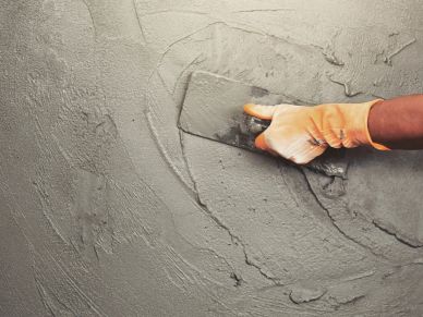 Hand smoothing wet cement with a trowel.