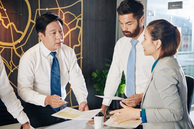 Experienced Vietnamese entrepreneur talking to his team and reprioritizing initiatives to take advantage of new opportunities