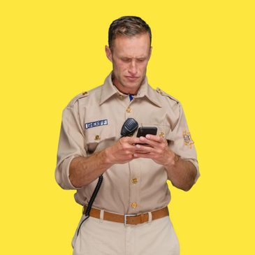 Sheriff in uniform focused on his phone against a yellow background.