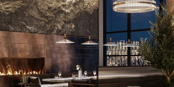 Modern restaurant interior with pendant lights, fireplace, and elegant table setting. 