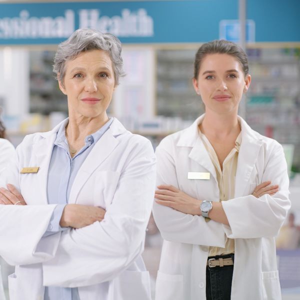 Three confident female healthcare professionals standing with arms crossed.