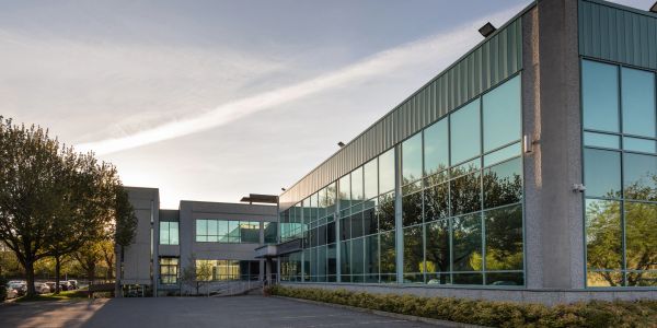 Modern office building with glass windows at sunset.