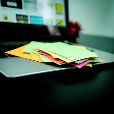 Colorful sticky notes stacked on a laptop keyboard.