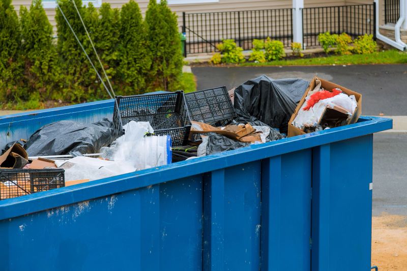 Construction trash dumpsters on metal container, house renovation.