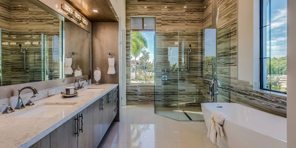 Wet room shower with freestanding bath down lights lit mirrors his and hers basins, feature tile wall