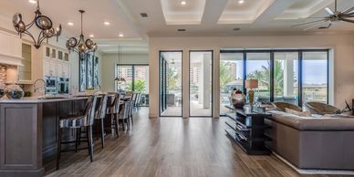 Spacious open-concept kitchen and living room with large windows and island seating.