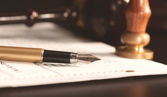 Three professionals reviewing documents at a wooden table in a cafe.