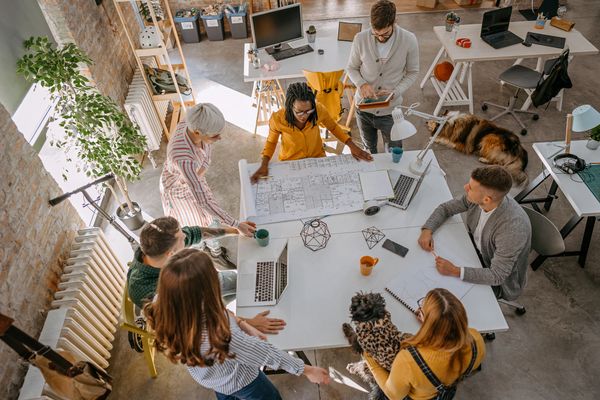 Team collaborating on architectural plans in a bright, modern office space.