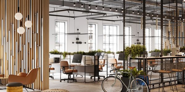 Modern office space with open desks, stylish seating, and industrial decor.