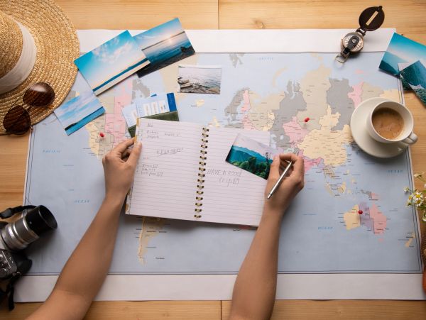Person planning a trip with photos and map.