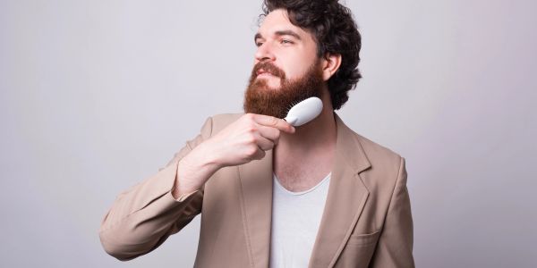 Man brushing his beard.