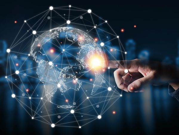 Finger interacting with digital network globe.