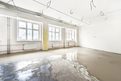 Commercial property affected by water damage showing standing water and saturated flooring.