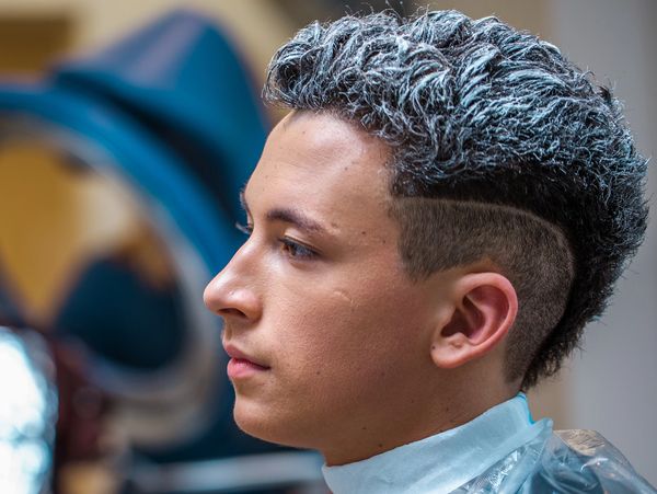 Man with a stylish dyed hairstyle.