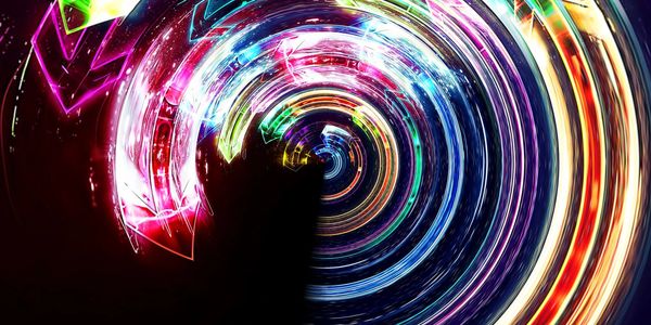 Colorful neon arrows swirling in a vibrant circular vortex against a dark background.