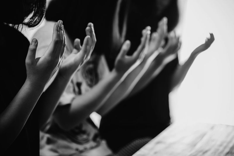 Black and white of group people praying worship believe. soft focus, praying and praise together at church. devotional or prayer meeting concept.