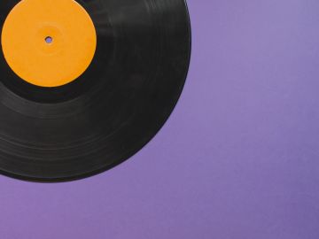 Black vinyl record with an orange label on purple background.