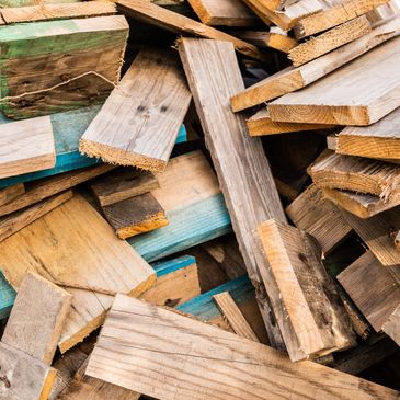 Pile of assorted wooden planks and boards stacked together.