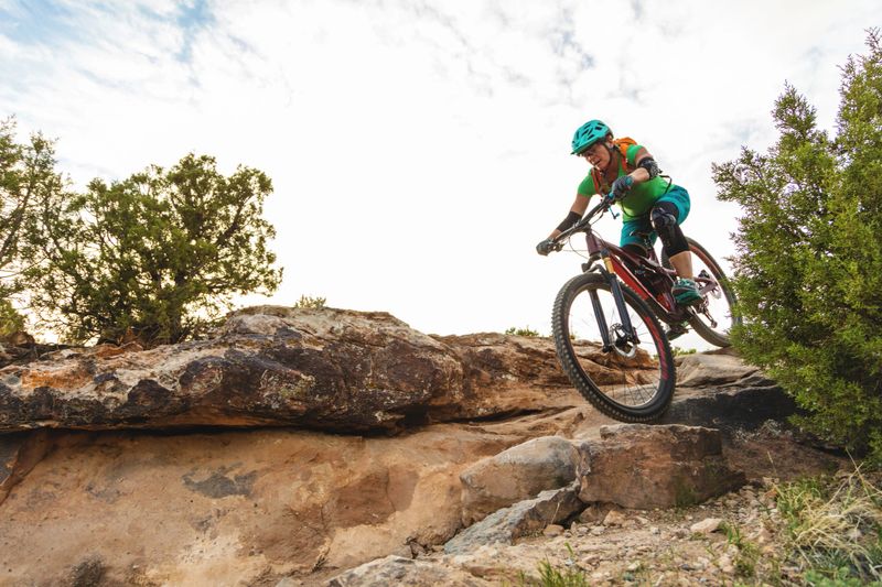 Mature Adult Female Adult Female Mountain Biking in Western Colorado Desert Arid Climate late Evening (Shot with Canon 5DS 50.6mp photos professionally retouched - Lightroom / Photoshop - original size 5792 x 8688 downsampled as needed for clarity and select focus used for dramatic effect)