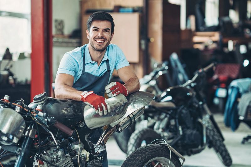 Portrait of a smiling motorcycle mechanic in his workshop