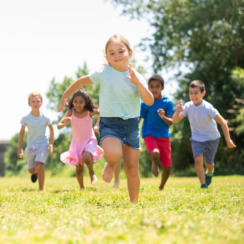 Group of happy kids  running in race in the street and laughing in park