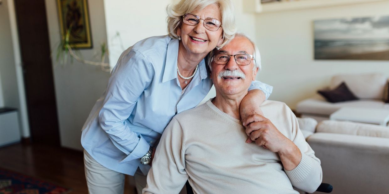 Happy elderly couple smiling indoors.