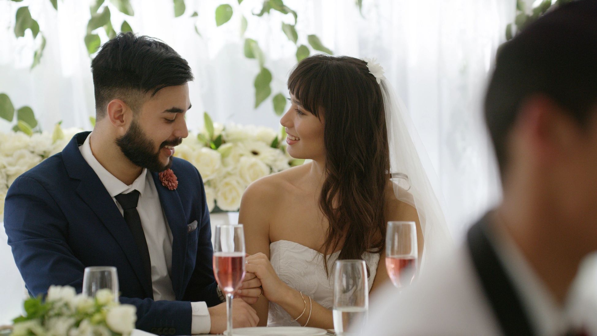 Bride and groom smiling at each other during wedding reception.
