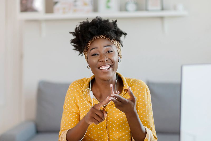 Pretty African American Woman Looking at Camera and Taking Part Video call Involved in Virtual Conferencing With Colleagues During Video Conference in the Office