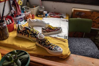 Custom painted sneakers on a cluttered artist's workspace.