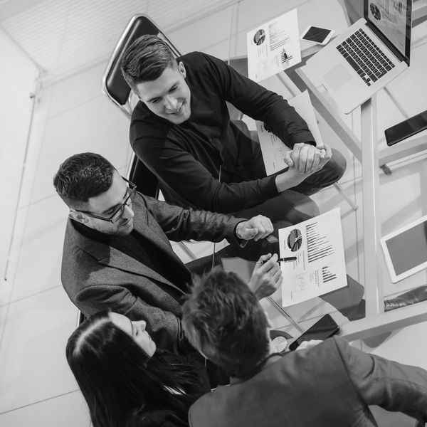 Three business professionals discussing charts and data in a meeting.