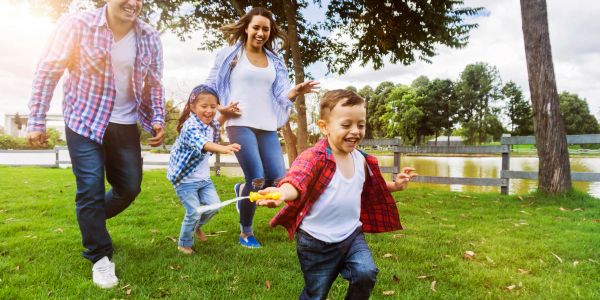 Family enjoys playing outdoors on a sunny day.