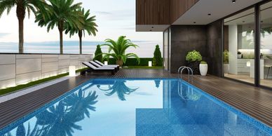 Modern outdoor pool area with palm trees and lounge chairs.