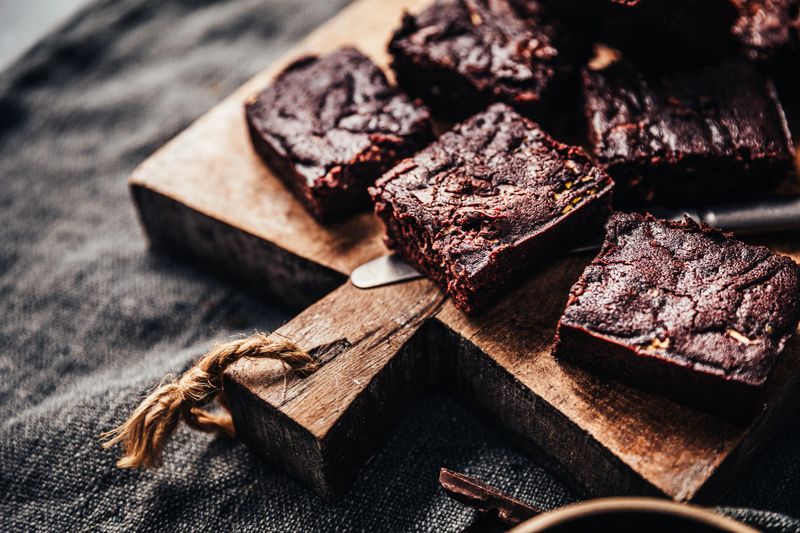 Pieces of vegan cucumber brownie on a wooden board. Chocolate brownies served on a wooden plate.