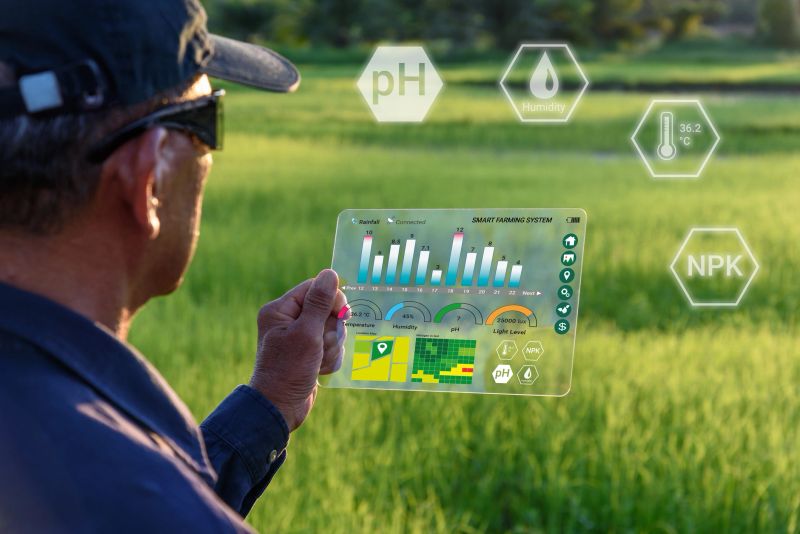 Farmer wears VR or AR glasses while monitoring rainfall, temperature, humidity, soil pH with immersive experience on digital holographic screen