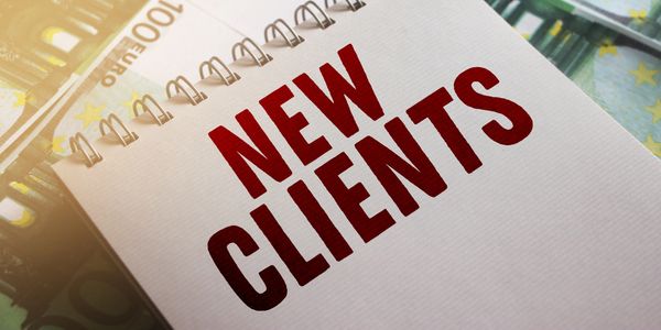 A notepad with two words in red capitals that reads new clients.