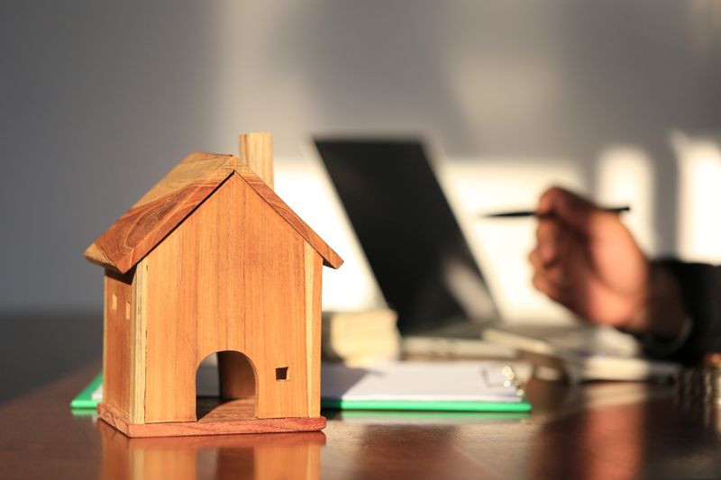 Model house and businessman signing documents on the table, New home and ownership property concept