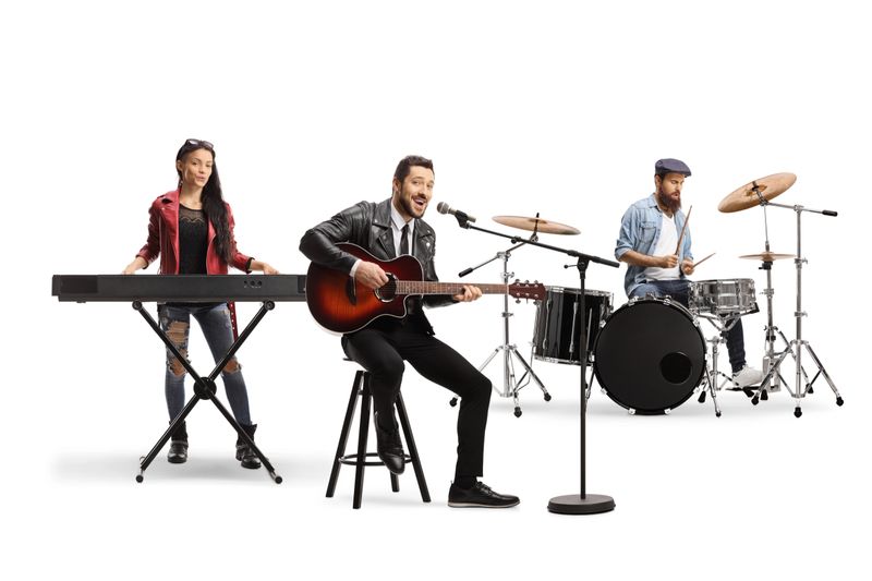 People in a music band with an acoustic guitar, keyboard and drums isolated on white background