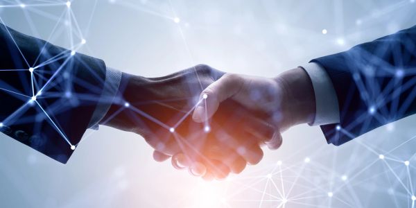 Two business professionals shaking hands in a digital network environment.
