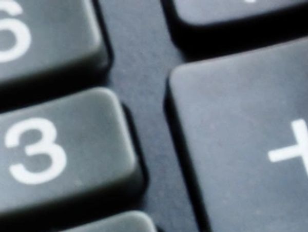 Close-up of black calculator keys showing number 3 and a plus sign.